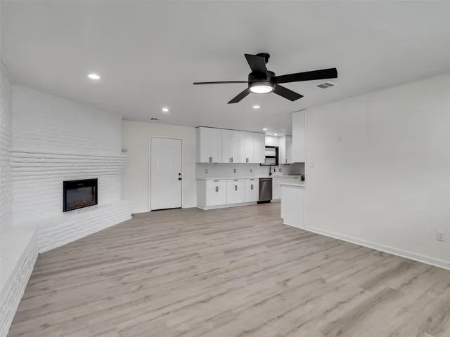 a view of empty room with wooden floor and window