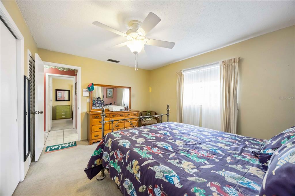 3801 Chinaberry Road Bradenton, FL 34208 - Photo 15 of 31 a bedroom with a large bed and a chandelier