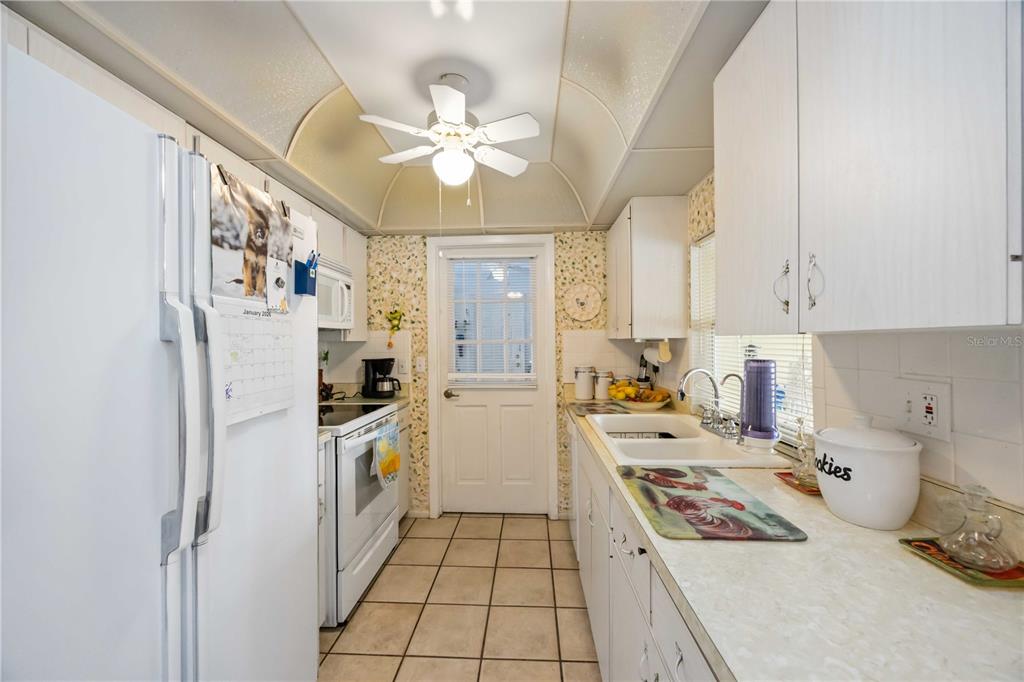 3801 Chinaberry Road Bradenton, FL 34208 - Photo 9 of 31 a kitchen with a refrigerator a stove top oven a sink and dishwasher