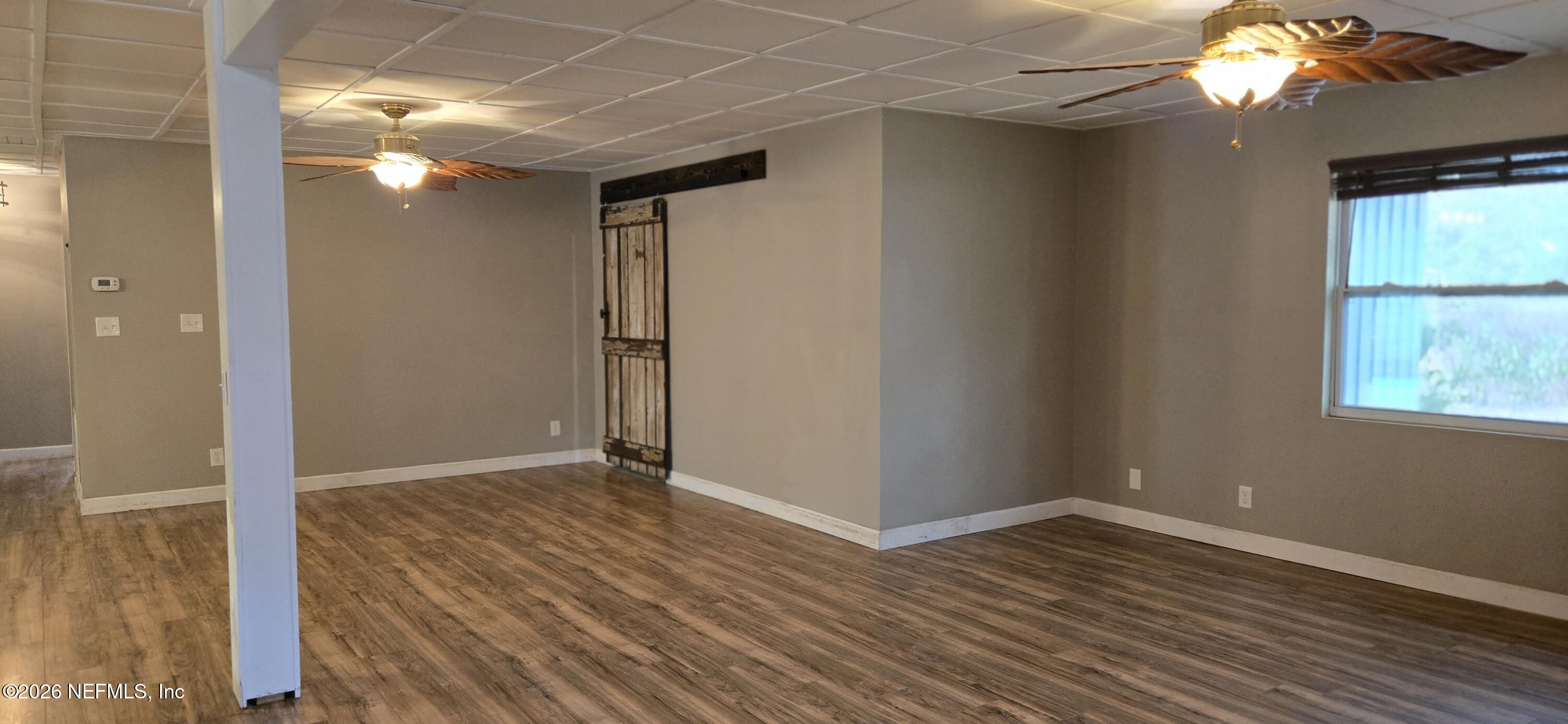 2720 Crystal Place Hilliard, FL 32046 - Photo 11 of 35 an empty room with wooden floor and windows