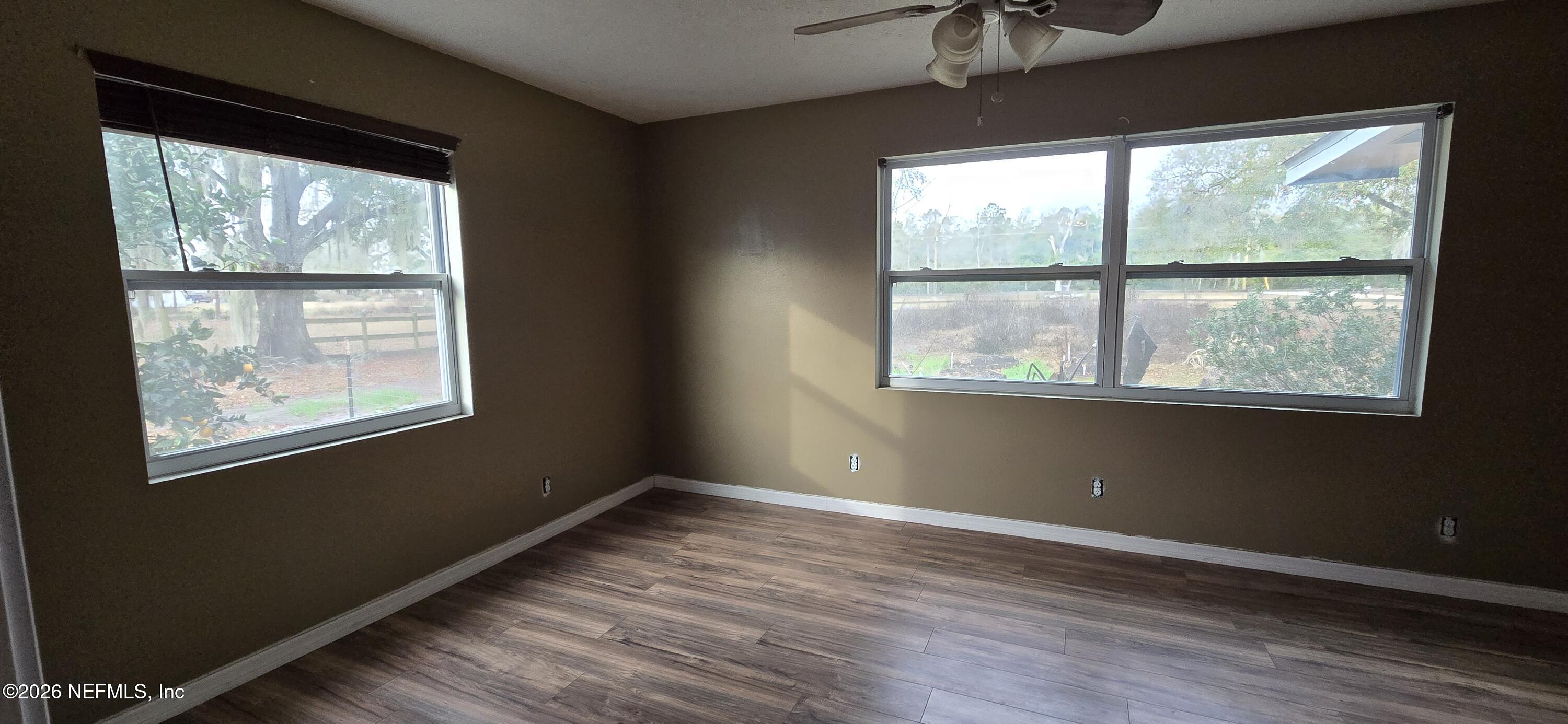 2720 Crystal Place Hilliard, FL 32046 - Photo 14 of 35 a view of an empty room with wooden floor and a window