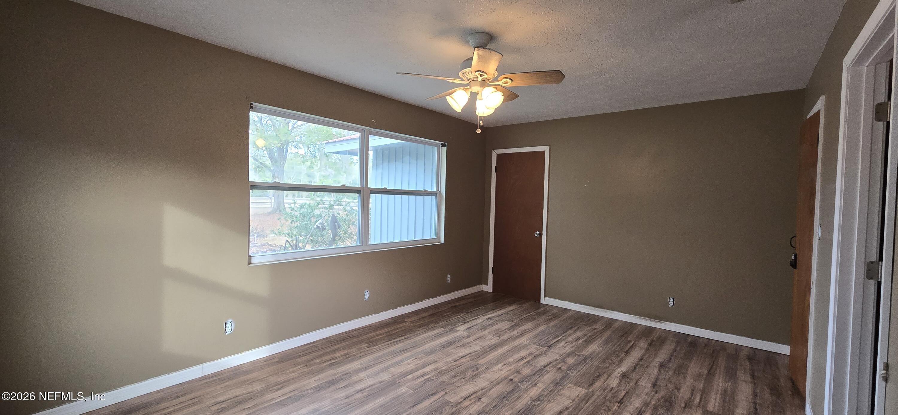2720 Crystal Place Hilliard, FL 32046 - Photo 16 of 35 a view of an empty room with a window and wooden floor