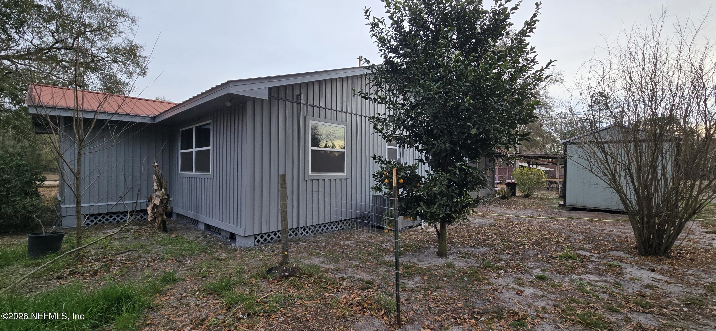 2720 Crystal Place Hilliard, FL 32046 - Photo 21 of 35 a view of a house with a tree and wooden fence