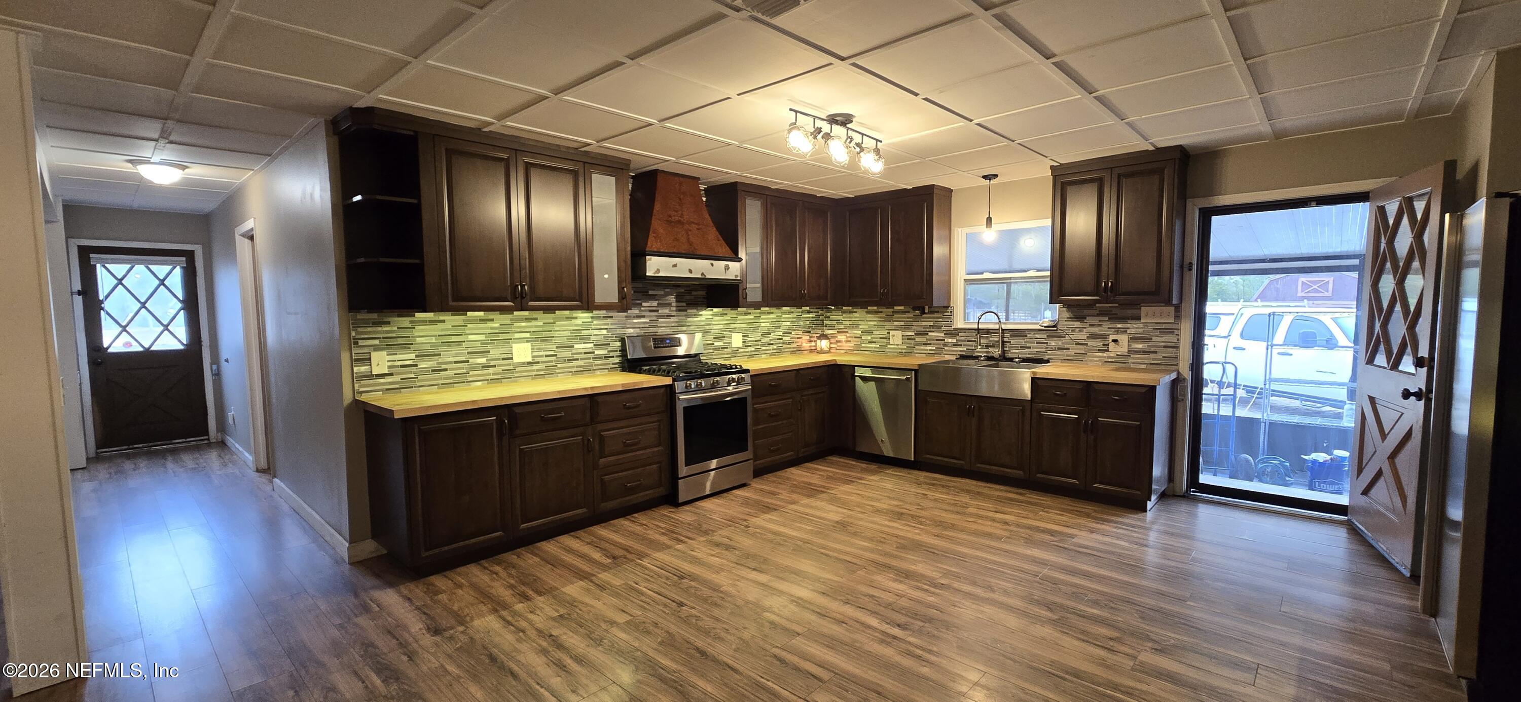 2720 Crystal Place Hilliard, FL 32046 - Photo 7 of 35 a kitchen with stainless steel appliances granite countertop wooden floors and sink