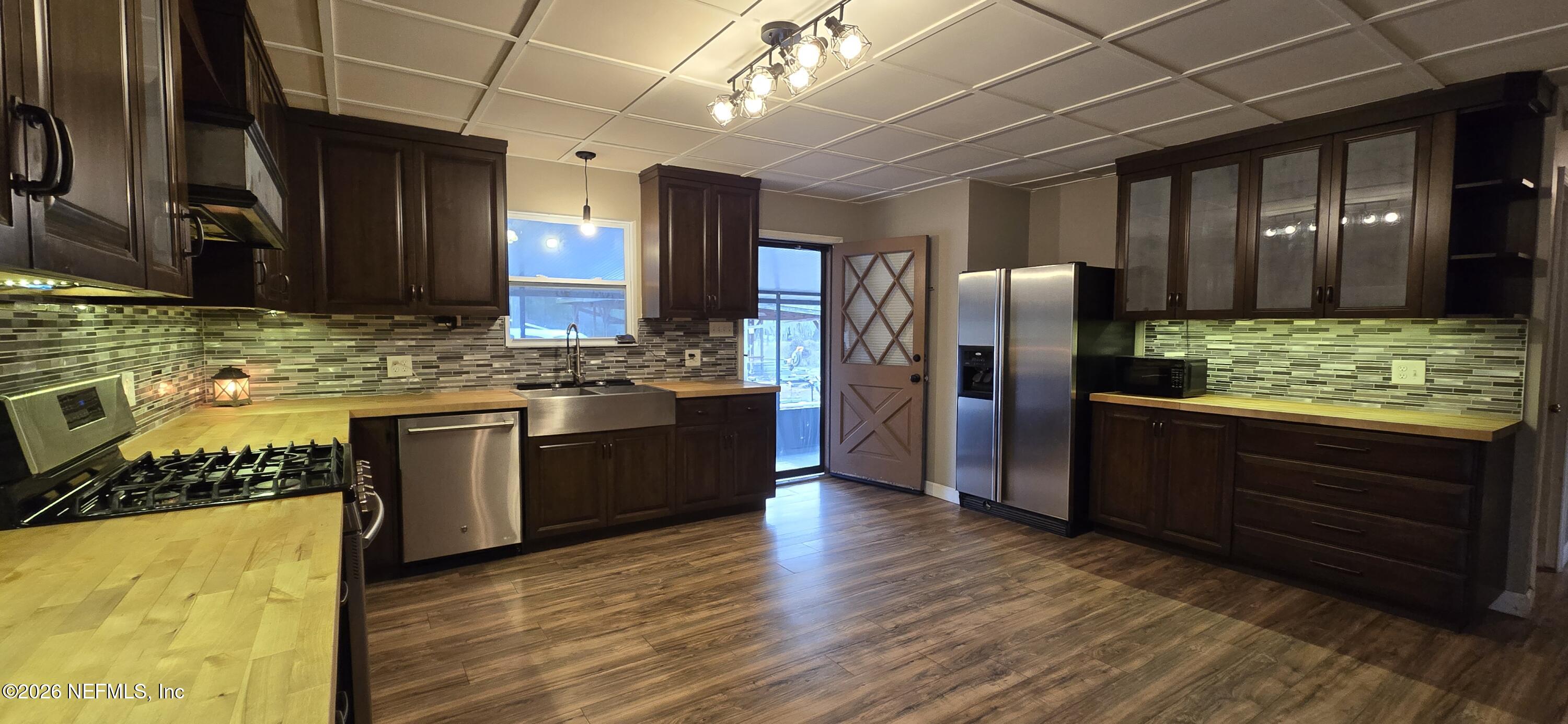 2720 Crystal Place Hilliard, FL 32046 - Photo 8 of 35 a kitchen with stainless steel appliances granite countertop wooden cabinets and a counter top space