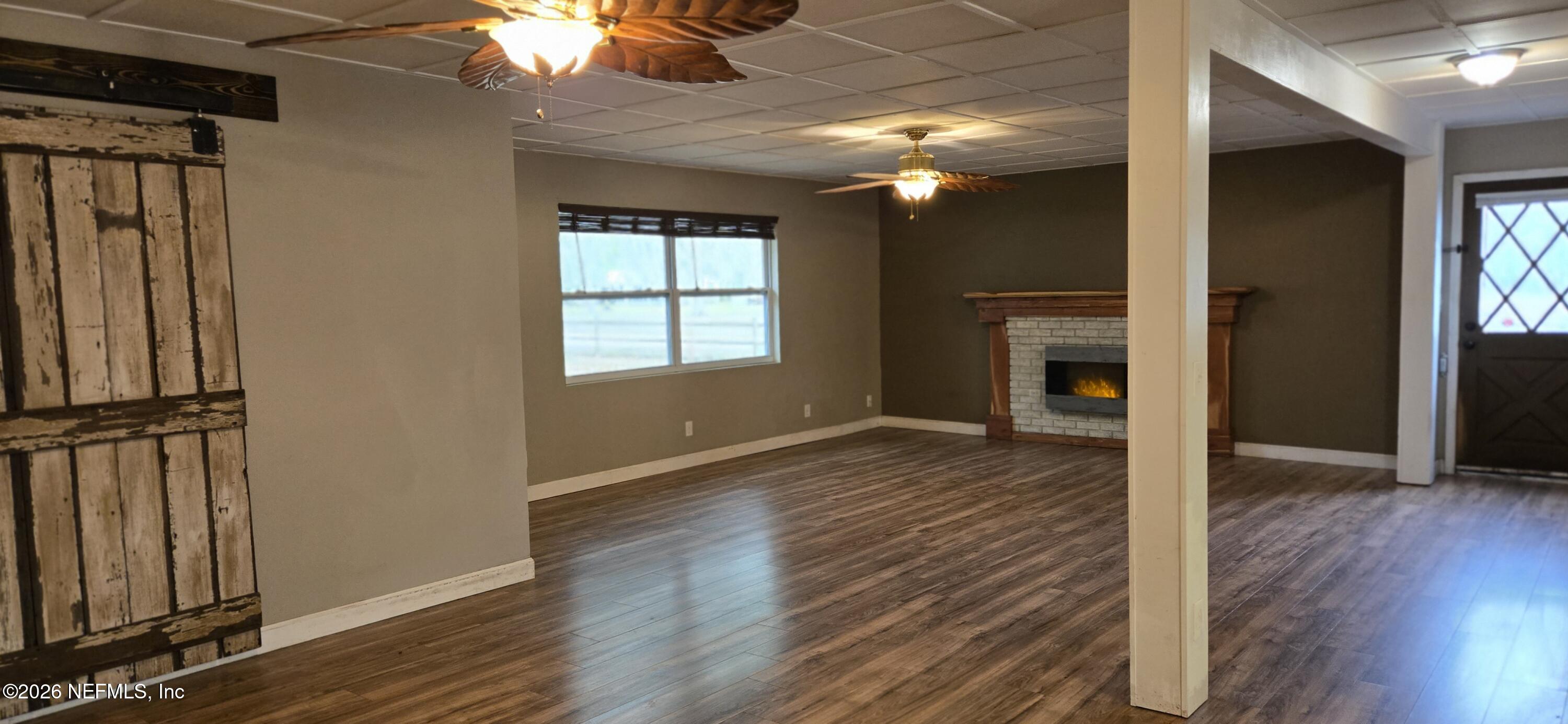 2720 Crystal Place Hilliard, FL 32046 - Photo 10 of 35 an empty room with wooden floor cabinet and windows