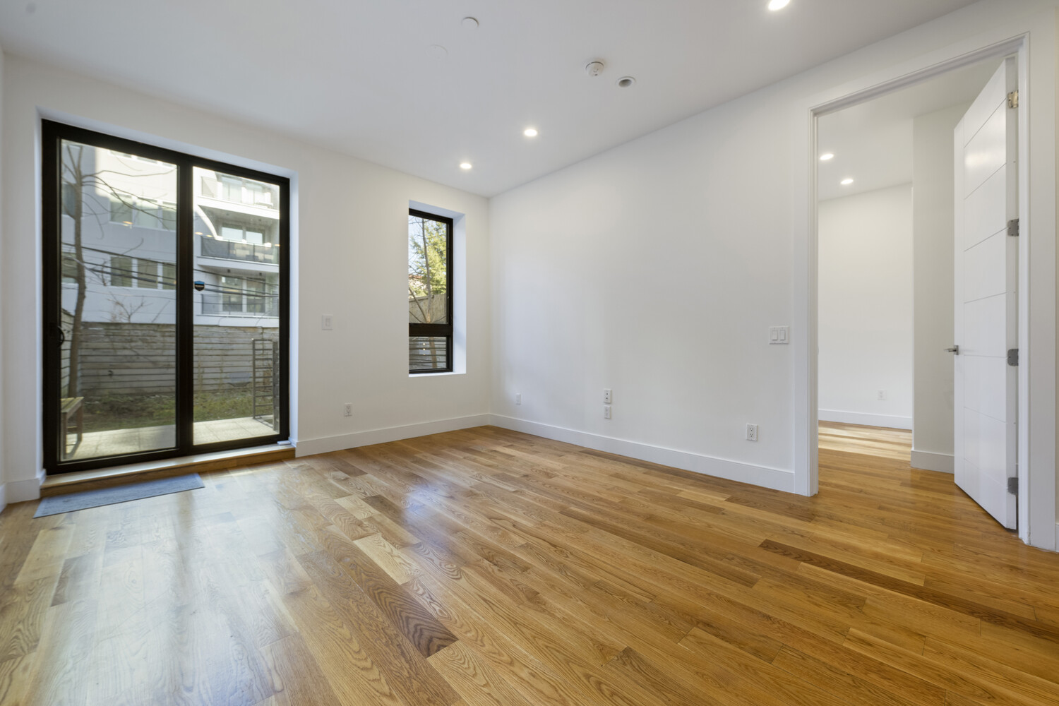 79 Clay Street, Unit 1R Brooklyn, NY 11222 - Photo 3 of 11 a view of an empty room with wooden floor and a window