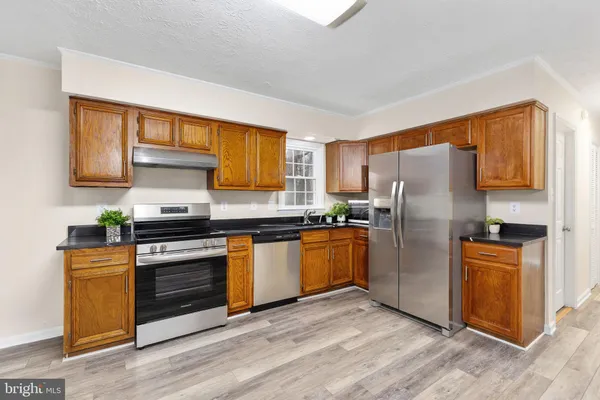 a kitchen with stainless steel appliances granite countertop a refrigerator and a stove top oven