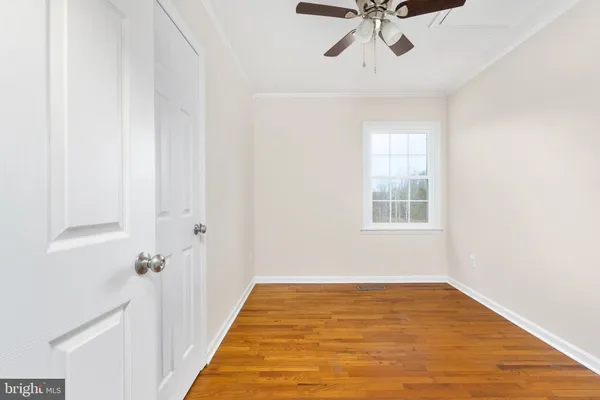 a view of empty room with wooden floor