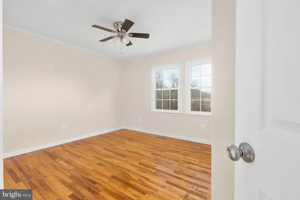 a view of empty room with wooden floor