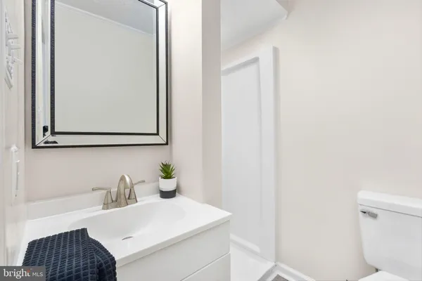 a bathroom with a sink vanity mirror and toilet