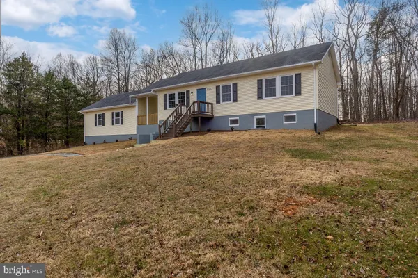 a view of a house with backyard and wooden fence