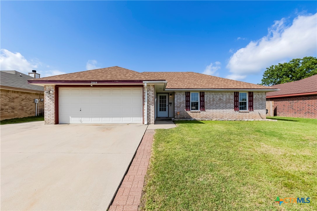a front view of a house with a garden and yard