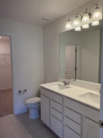 a bathroom with a toilet a sink and mirror