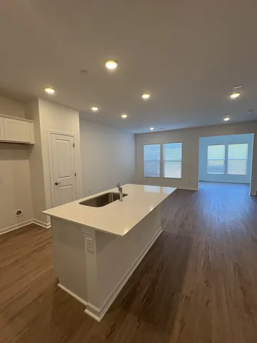 a view of a kitchen with a sink and wooden floor