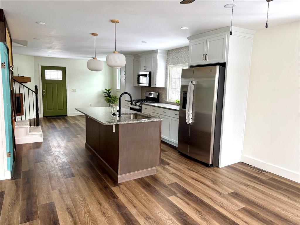 7914 Hemlock Street Pittsburgh, PA 15237 - Photo 11 of 37 a kitchen with stainless steel appliances granite countertop a refrigerator a oven and a sink with wooden floor
