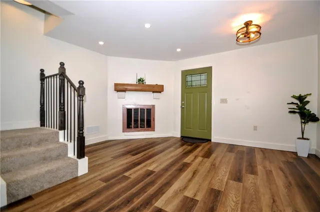 a view of a hallway with wooden floor and a fireplace