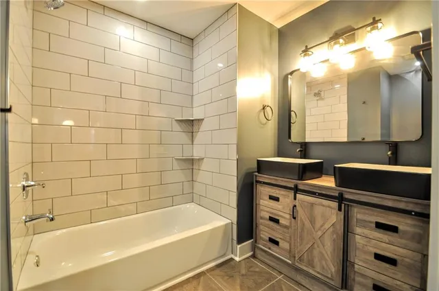 a bathroom with a bathtub sink vanity and mirror