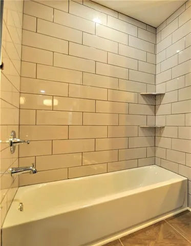 a bathroom with a bathtub and shower