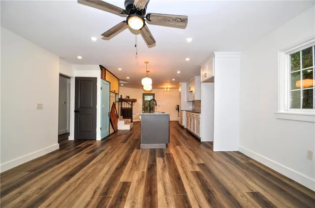 a view of a dining room with wooden floor and a ceiling fan