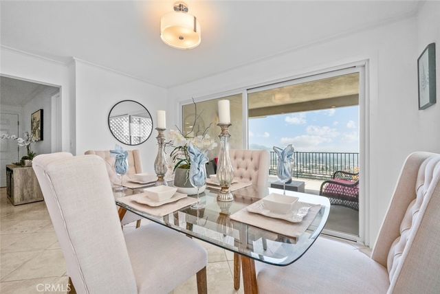 a dining room with furniture a large window and wooden floor