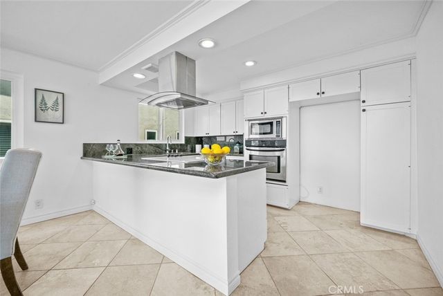 a kitchen with stainless steel appliances granite countertop a refrigerator sink and stove