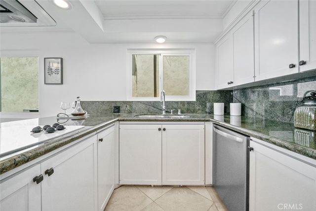 a kitchen with granite countertop white cabinets and white appliances