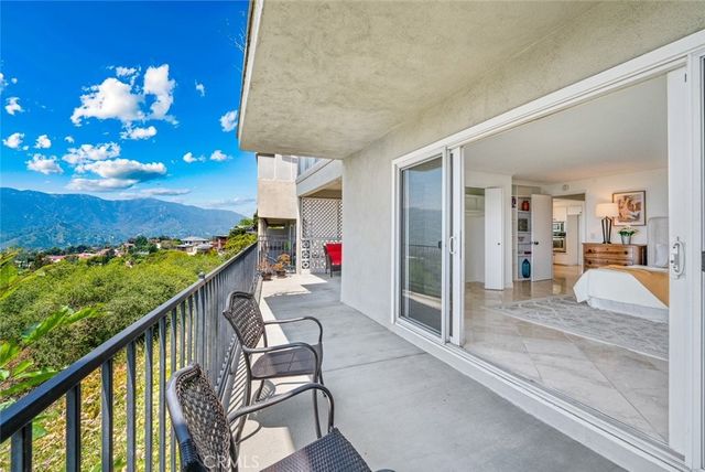 a balcony view with two chairs and a table