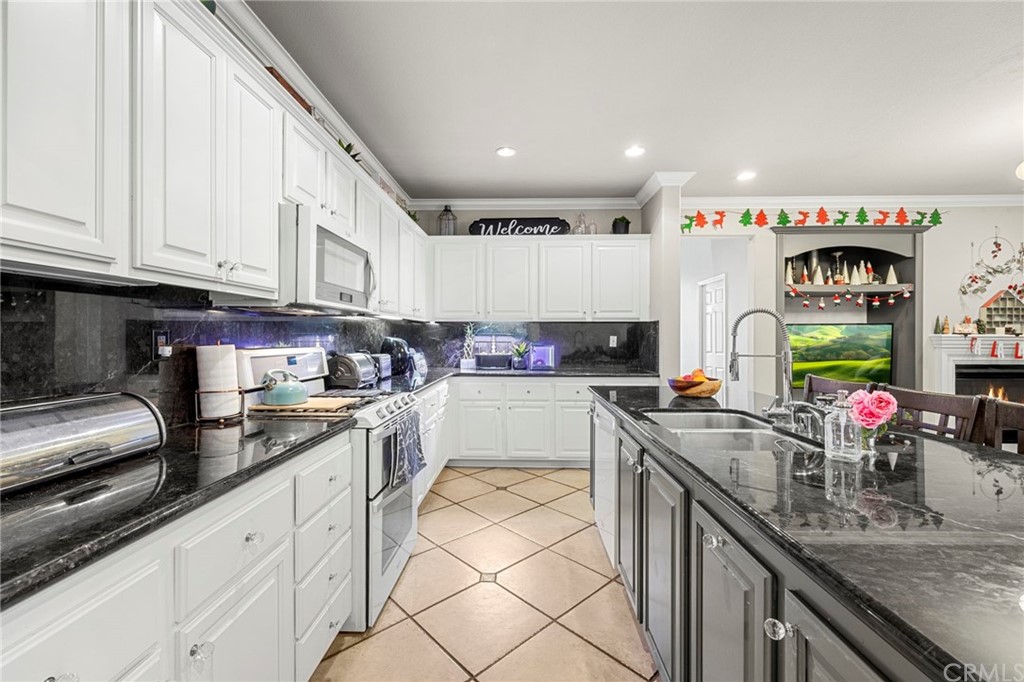 845 Dans Place Brea, CA 92821 - Photo 7 of 31 a kitchen with granite countertop a sink stainless steel appliances and white cabinets