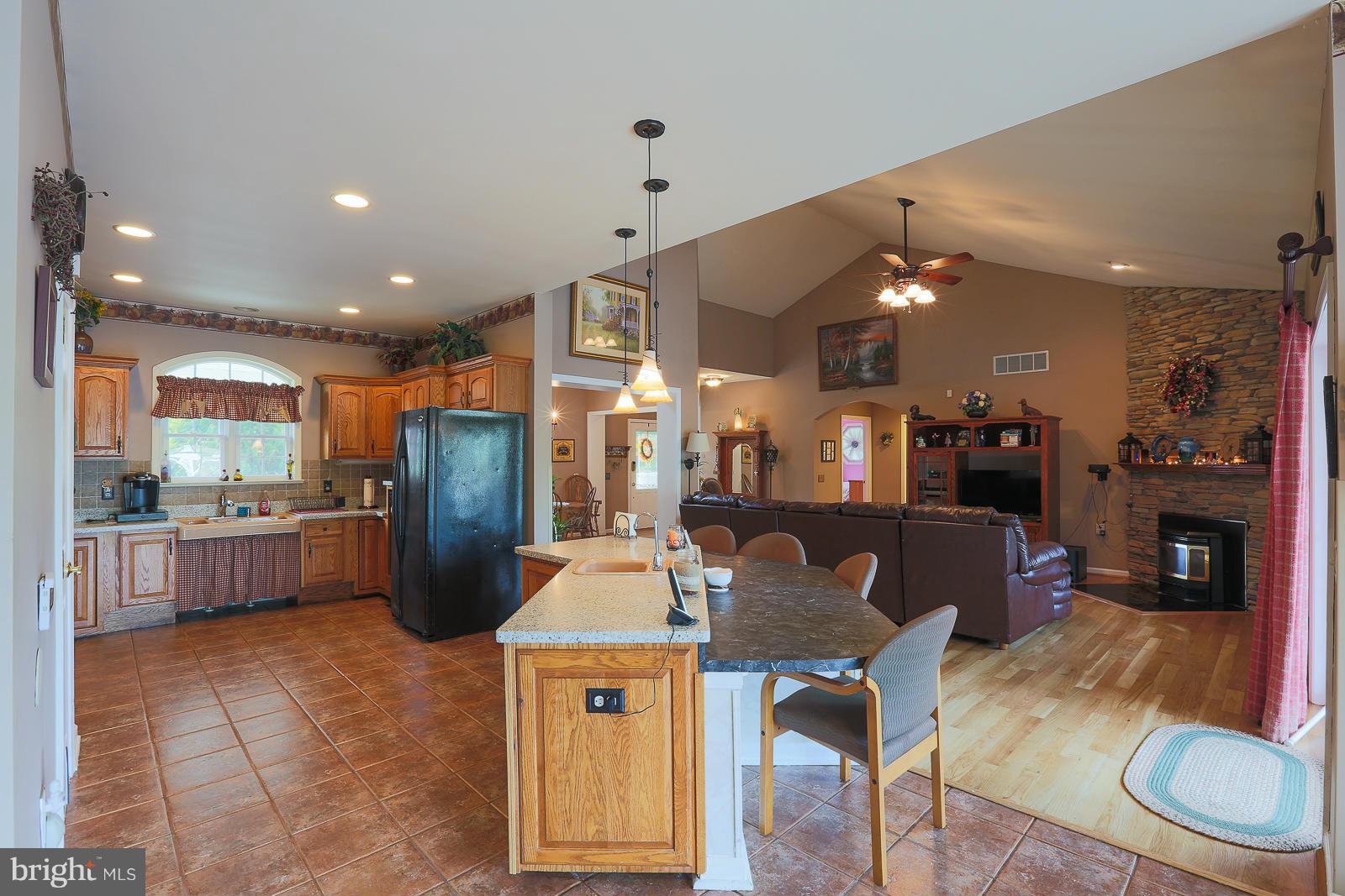 5020 Forge Road Perry Hall, MD 21128 - Photo 15 of 30 a kitchen with stainless steel appliances kitchen island granite countertop a refrigerator a stove a sink a dining table and chairs with wooden floor