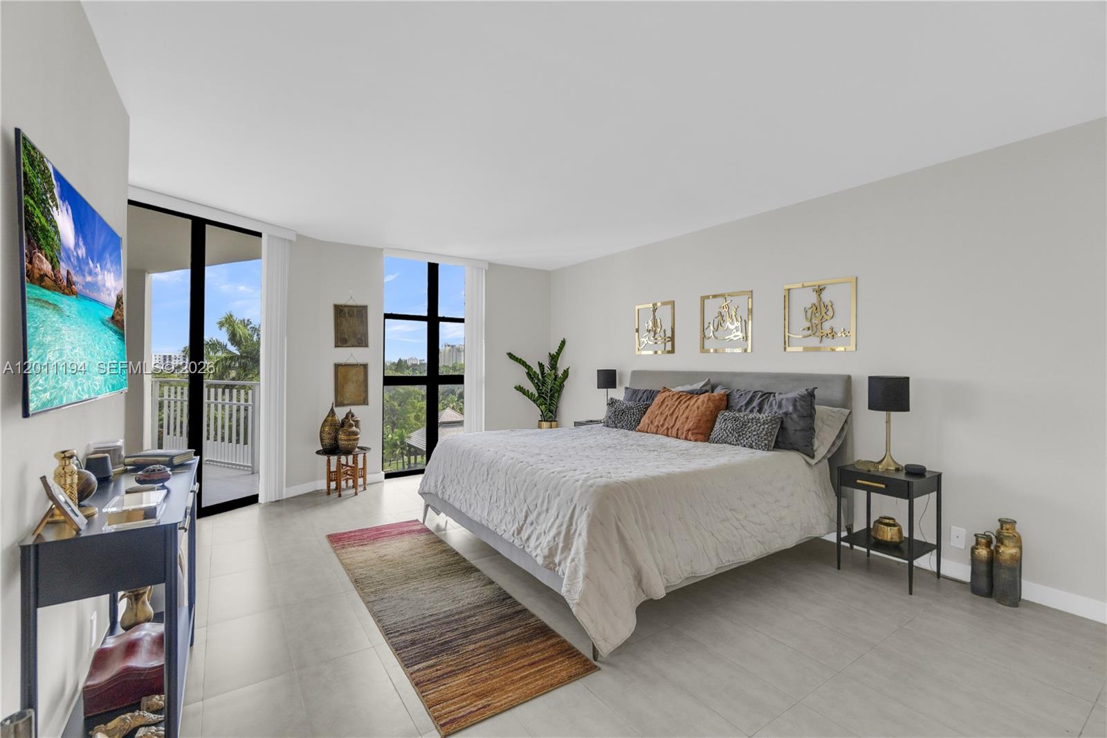 1000 Quayside Terrace, Unit 703 Miami, FL 33138 - Photo 15 of 31 a spacious bedroom with a bed couch and a large window