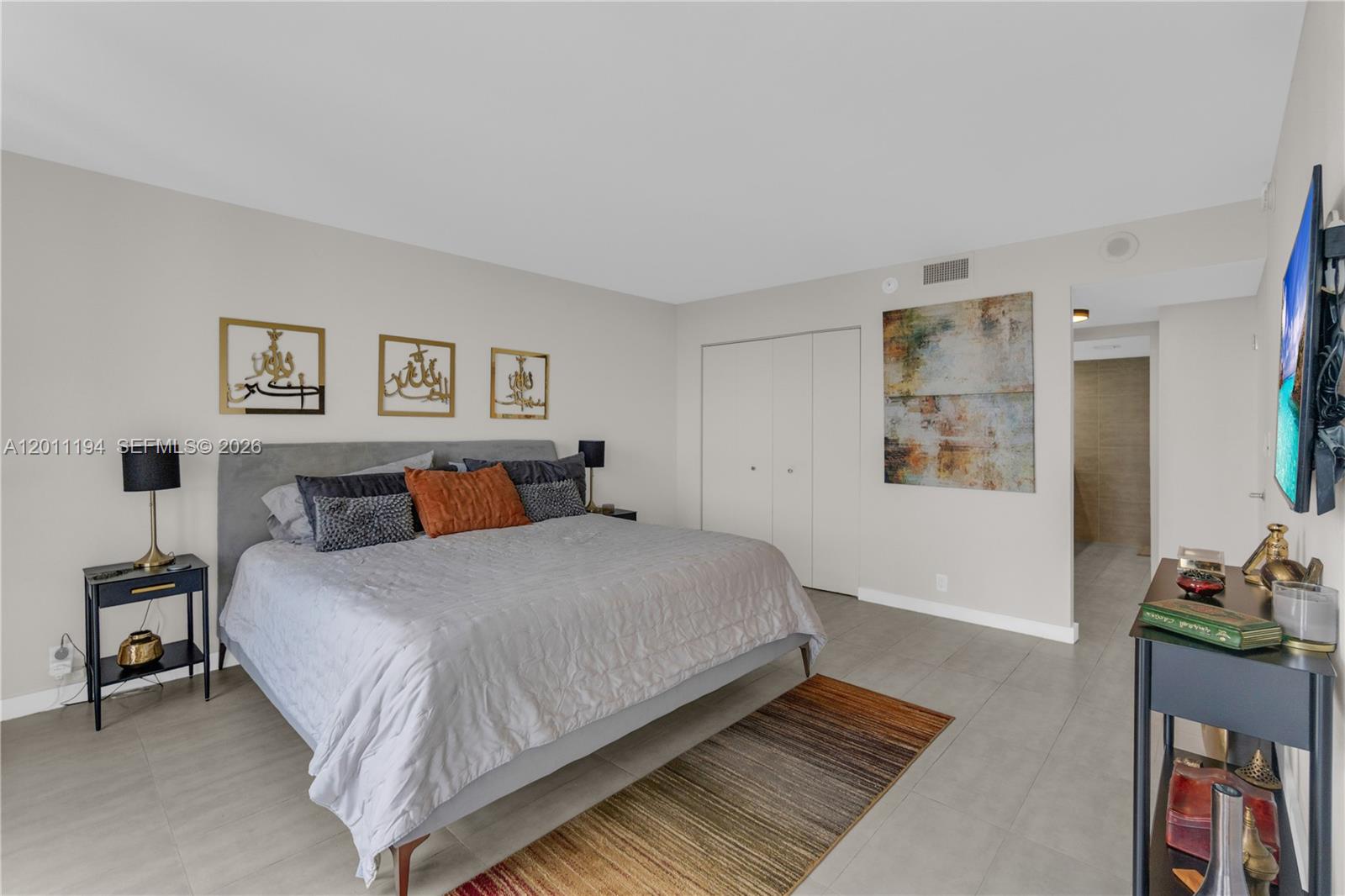 1000 Quayside Terrace, Unit 703 Miami, FL 33138 - Photo 16 of 31 a bedroom with bed and painting on the wall