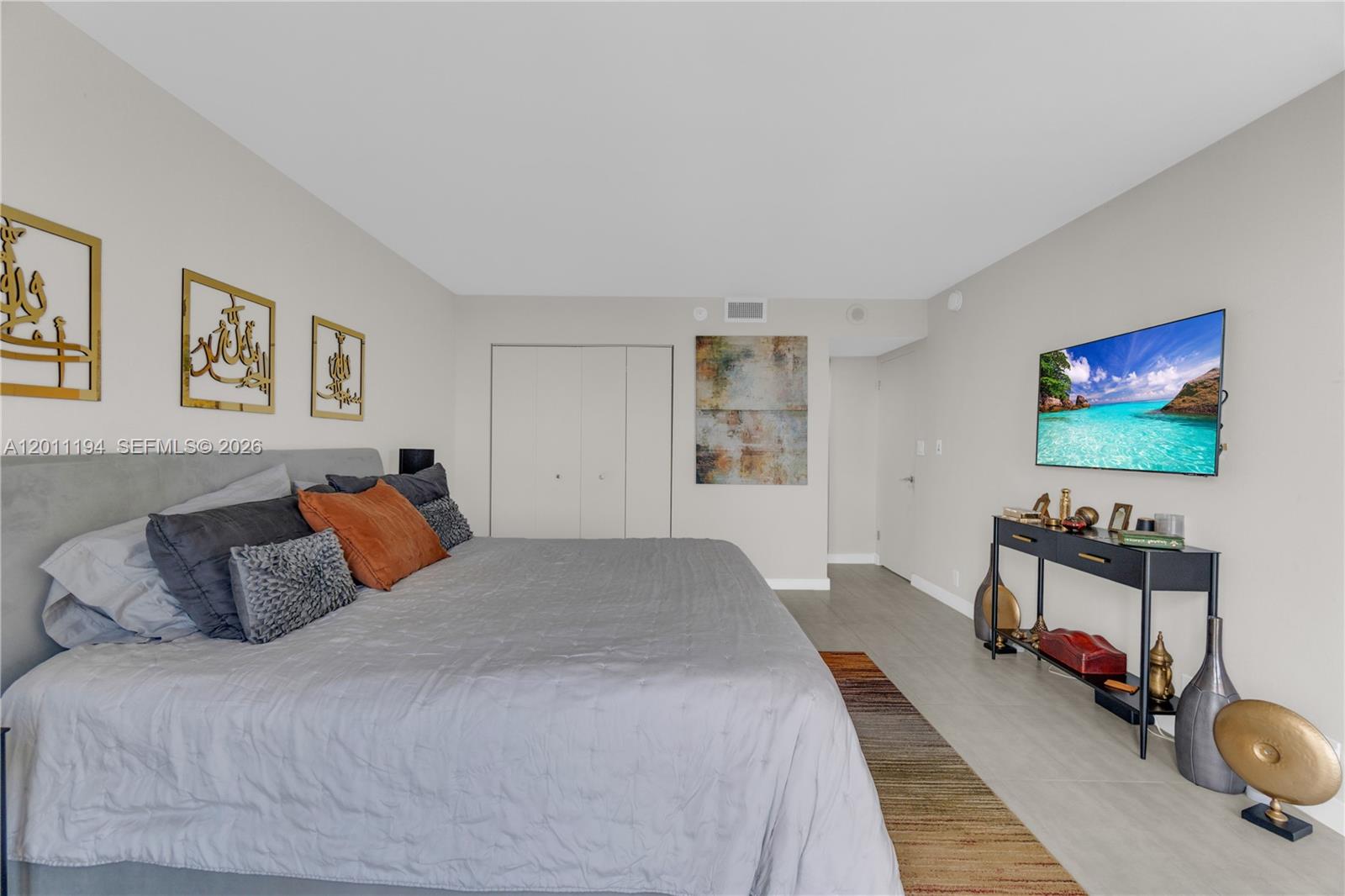 1000 Quayside Terrace, Unit 703 Miami, FL 33138 - Photo 17 of 31 a bedroom with bed and a flat screen tv