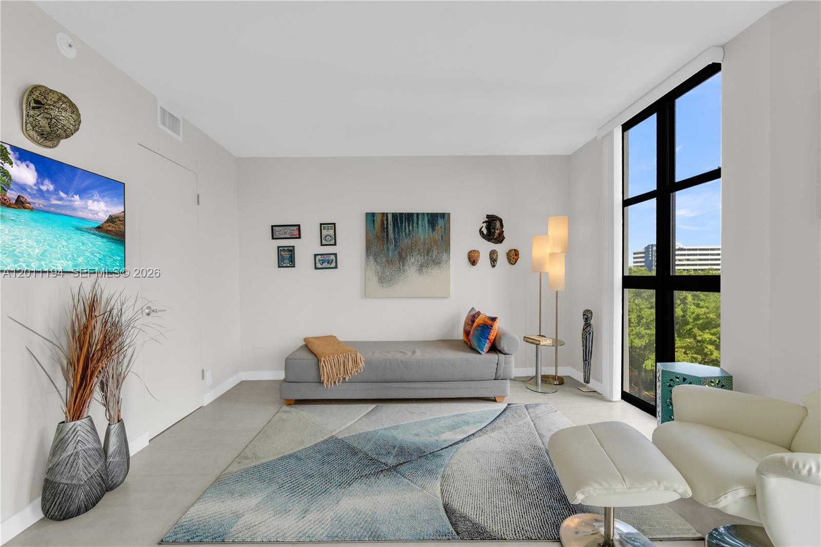 1000 Quayside Terrace, Unit 703 Miami, FL 33138 - Photo 20 of 31 a living room with furniture a floor to ceiling window and a flat screen tv