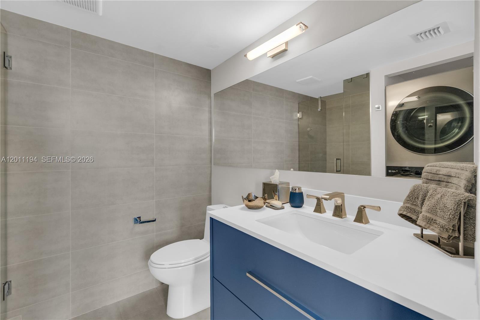 1000 Quayside Terrace, Unit 703 Miami, FL 33138 - Photo 23 of 31 a bathroom with a toilet a sink and mirror