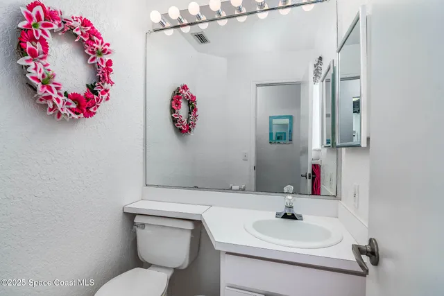 a bathroom with a sink mirror and toilet