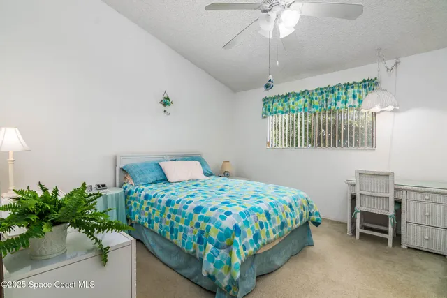a bedroom with a bed table and a window