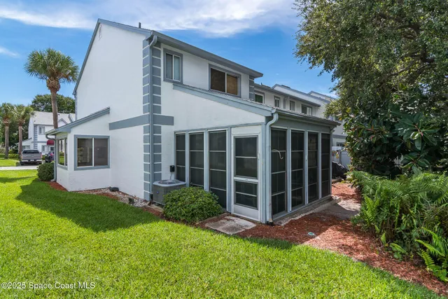 a view of a house with a yard and potted plants