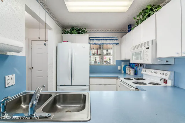 a kitchen with a sink a refrigerator and cabinets