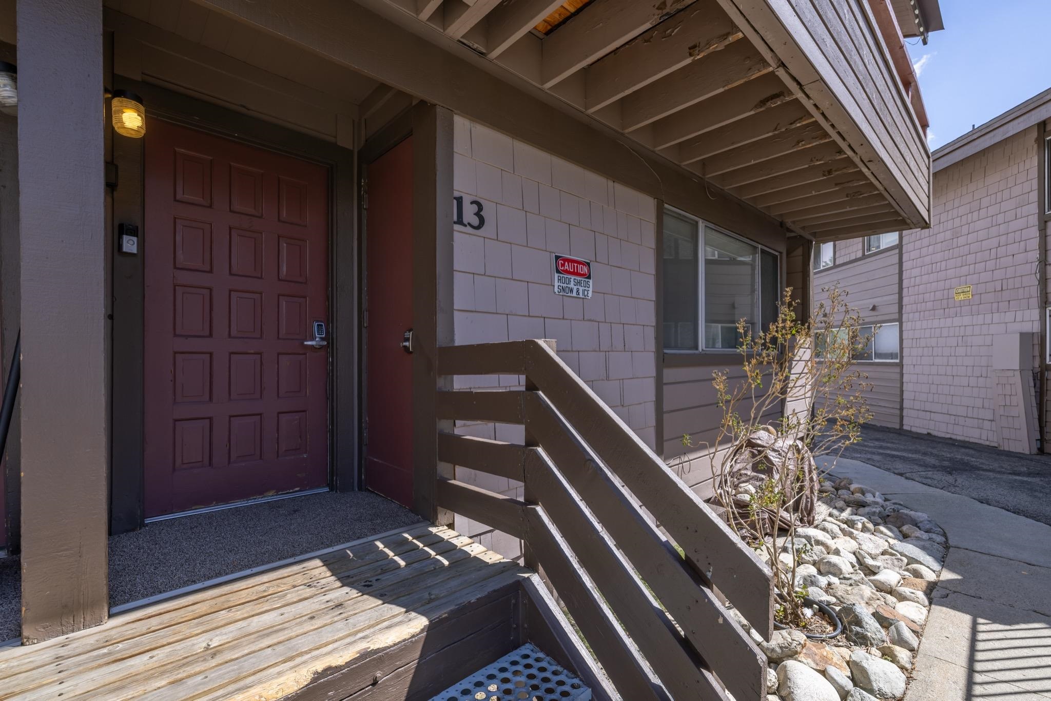 165 Old Mammoth Road, Unit 13 Mammoth Lakes, CA 93546 - Photo 19 of 23 Exterior entrance featuring a paneled door, overhead lighting fixture, and number 13