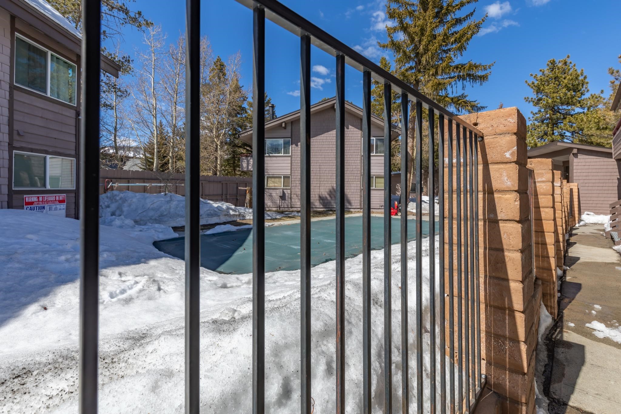 165 Old Mammoth Road, Unit 13 Mammoth Lakes, CA 93546 - Photo 20 of 23 Wrought iron fencing with brick pillars defines the property perimeter, offering a clear boundary