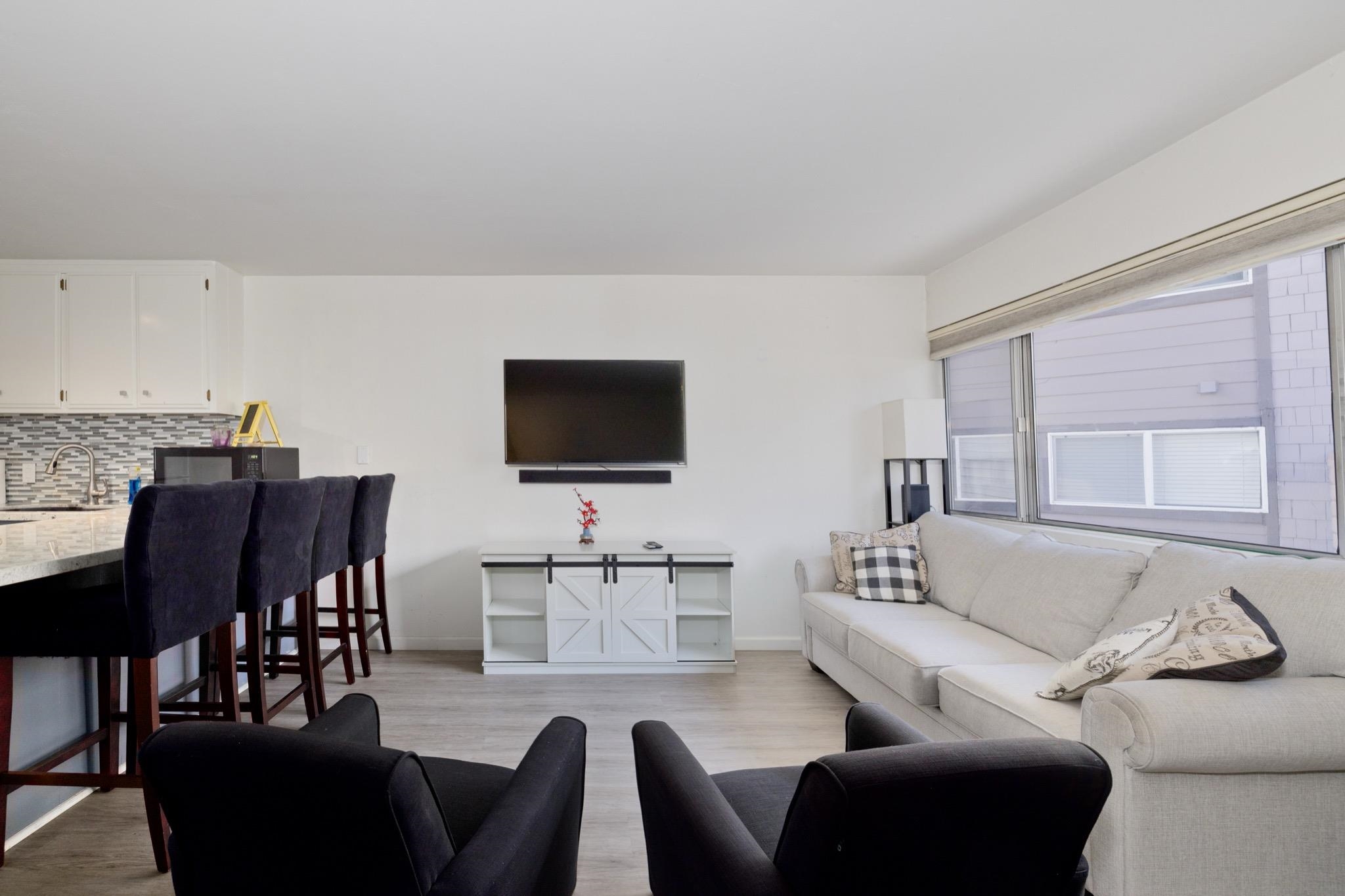165 Old Mammoth Road, Unit 13 Mammoth Lakes, CA 93546 - Photo 6 of 23 Open-concept living space featuring wood-finish flooring and ample natural light from extensive windows