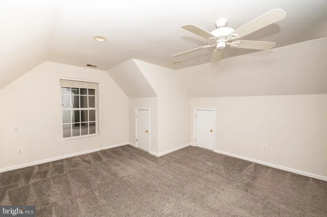 an empty room with a ceiling fan and a window