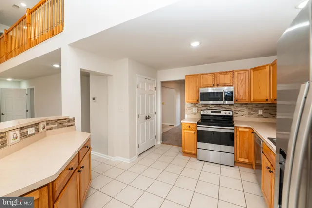 a large kitchen with a large counter top sink and stainless steel appliances