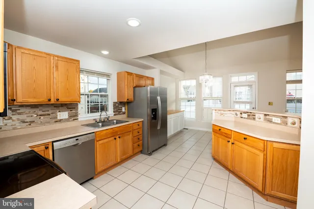 a kitchen with stainless steel appliances a refrigerator and a stove top oven