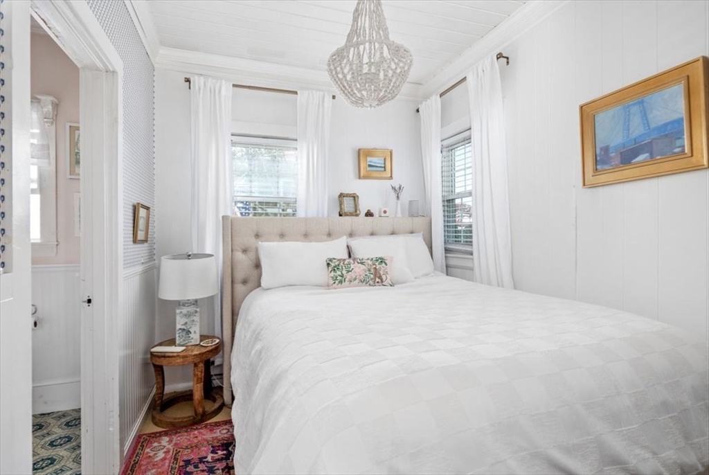 4 C Street Hull, MA 02045 - Photo 14 of 17 a bedroom with a bed and a chandelier