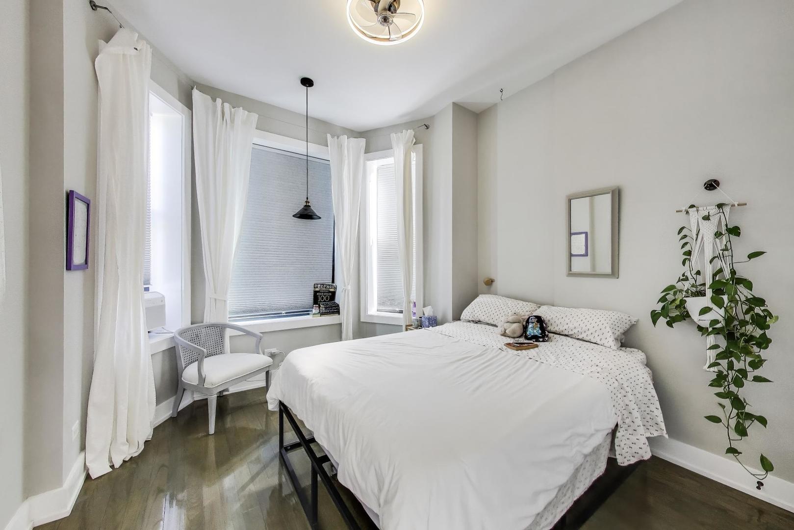 2742 West Polk Street Chicago, IL 60612 - Photo 23 of 50 a bedroom with a large bed and a chandelier