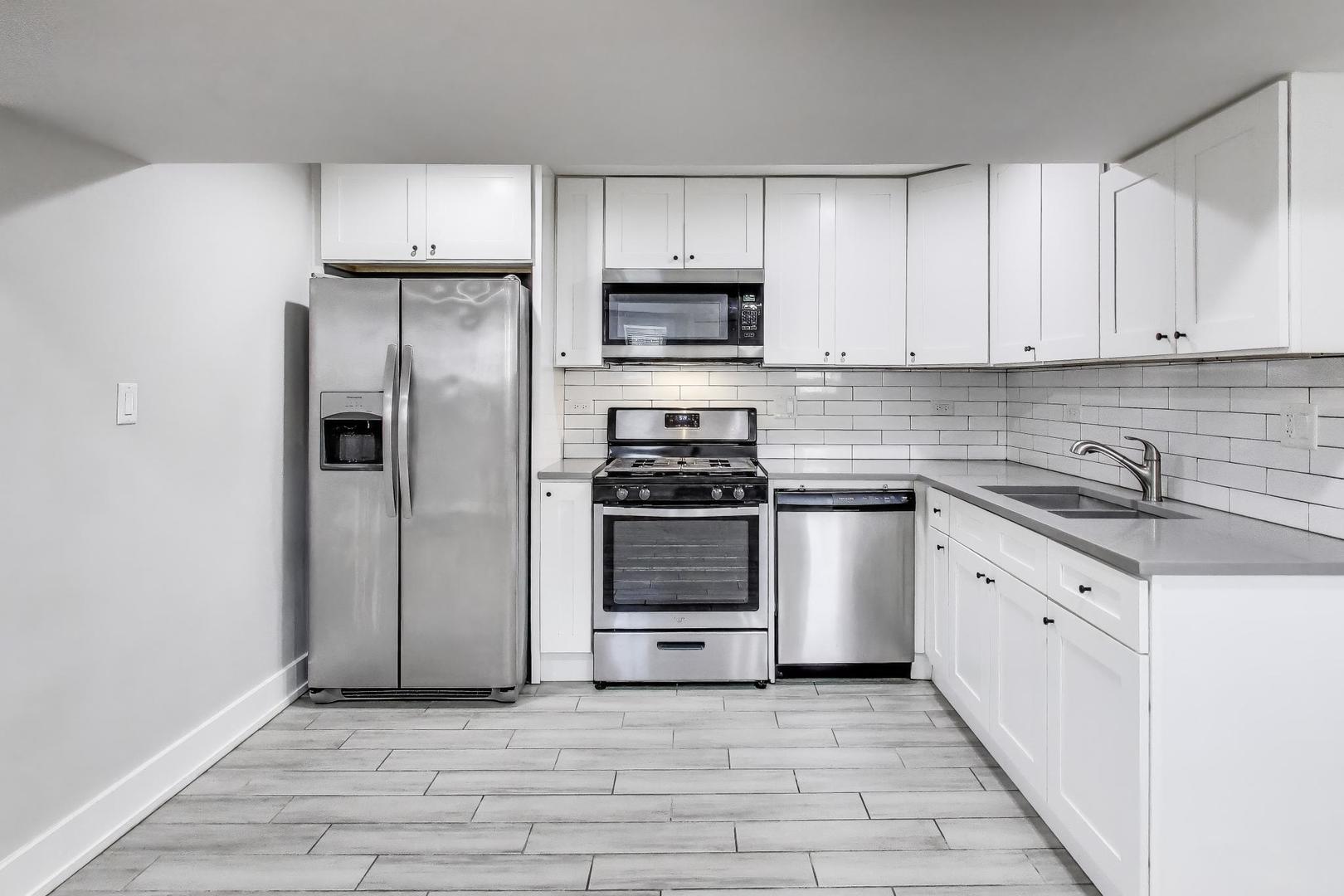 2742 West Polk Street Chicago, IL 60612 - Photo 31 of 50 a kitchen with white cabinets and stainless steel appliances