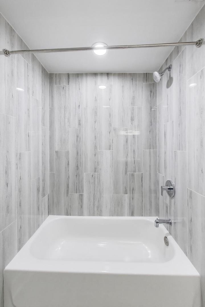 2742 West Polk Street Chicago, IL 60612 - Photo 40 of 50 a bathroom with a bathtub and a shower curtain
