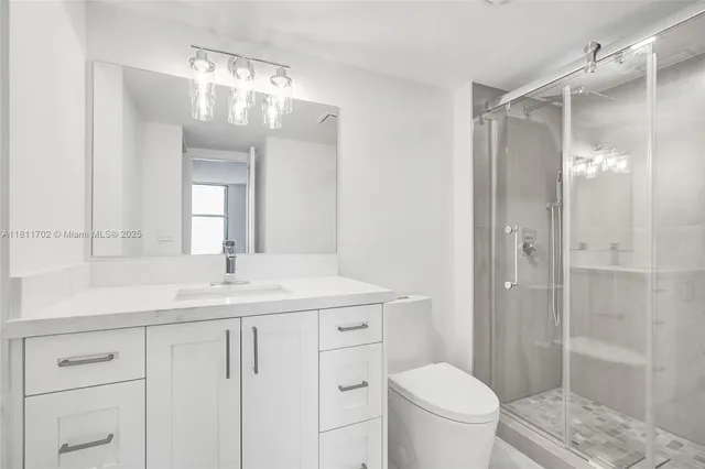 a bathroom with a granite countertop sink a toilet and a mirror